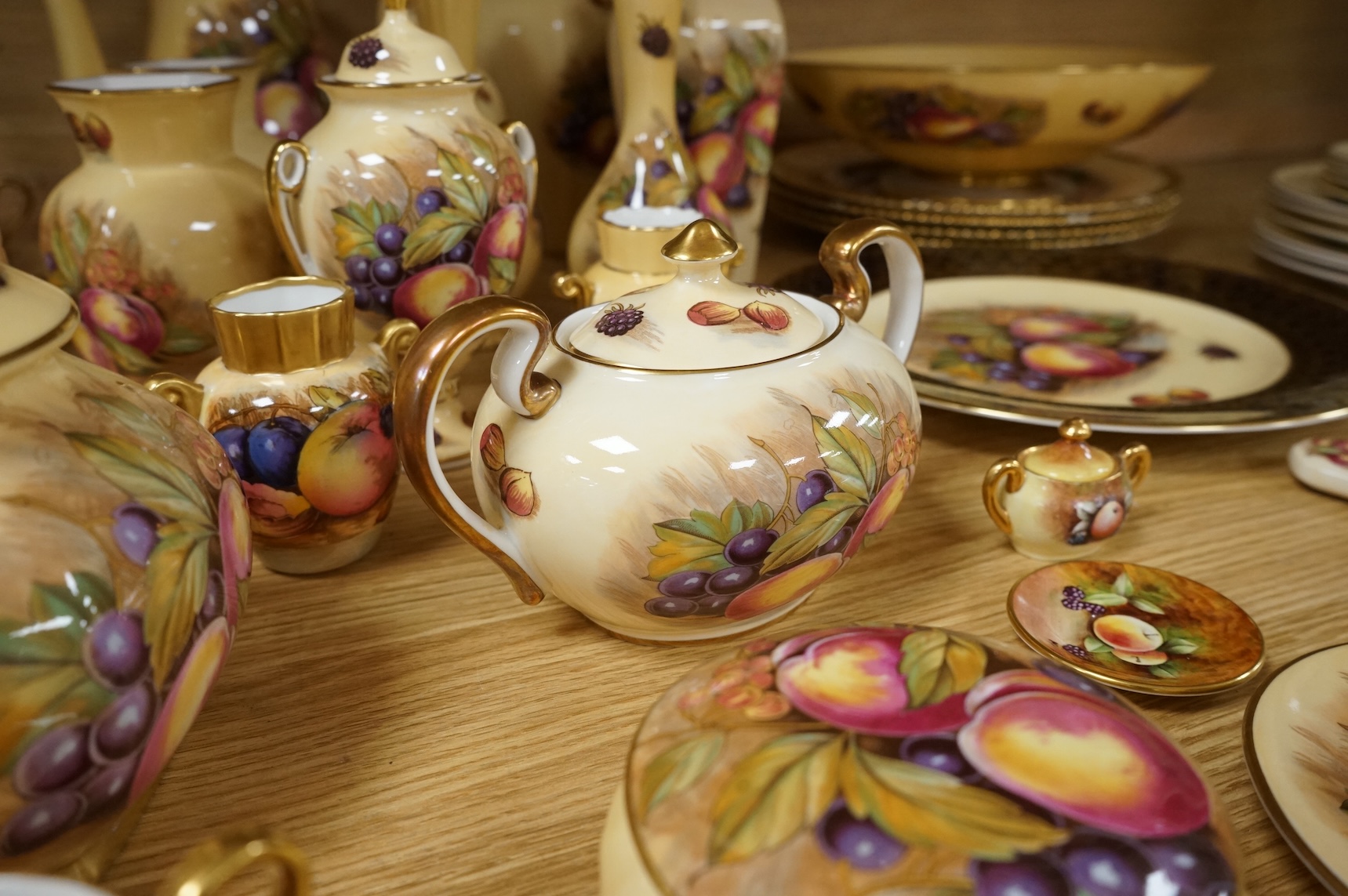 A collection of Aynsley ‘Orchard Gold’ fruit-painted tea/dinner wares and vases, largely signed by D Jones, largest 26cm in diameter